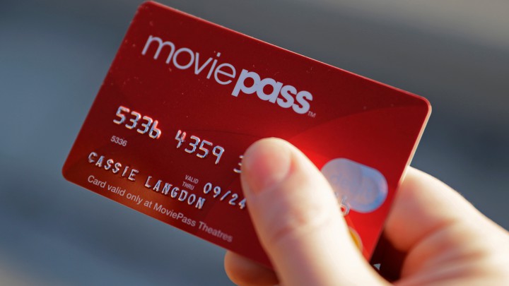 FILE - In this Jan. 30, 2018, file photo, Cassie Langdon holds her MoviePass card outside AMC Indianapolis 17 theatre in Indianapolis. MoviePass, the discount service for movie tickets, is raising prices by 50 percent and barring viewings of most major releases during the first two weeks. (AP Photo/Darron Cummings, File)